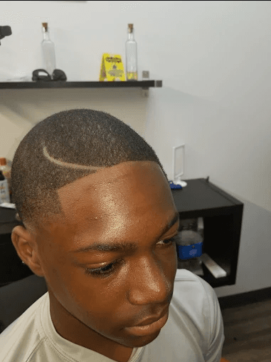 Clean buzz cut with precise line-up and curved part design